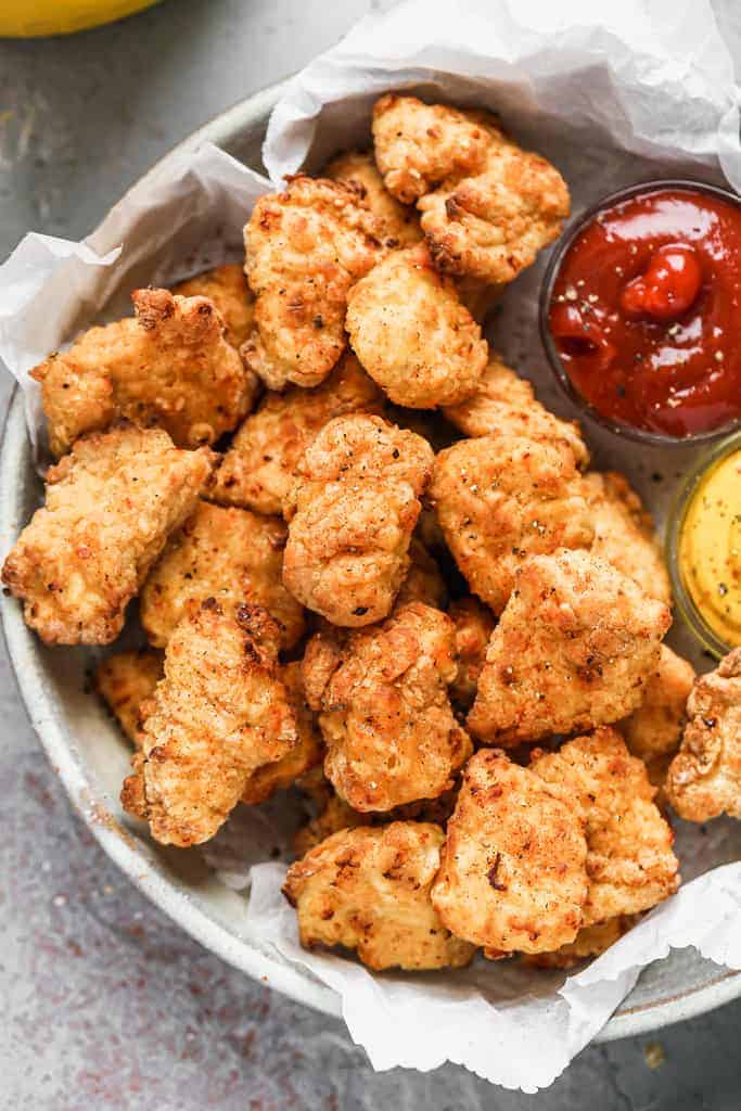 Air Fryer Chicken Nuggets served on a plate with dipping sauce.