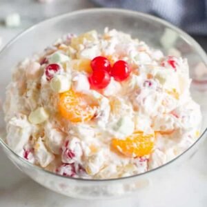A large serving bowl filled with Ambrosia Fruit Salad.