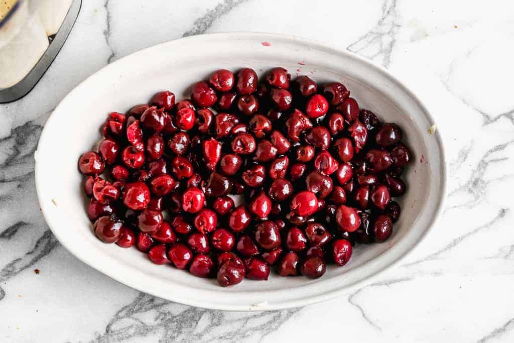 Red cherries in the bottom of a baking dish.