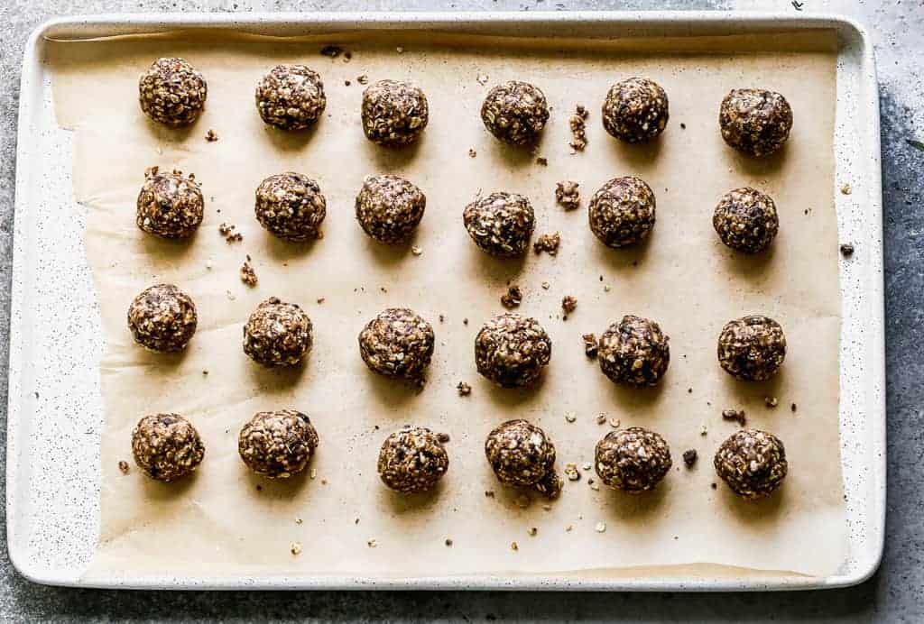 Granola Bites rolled into balls and placed on a baking tray lined with parchment.
