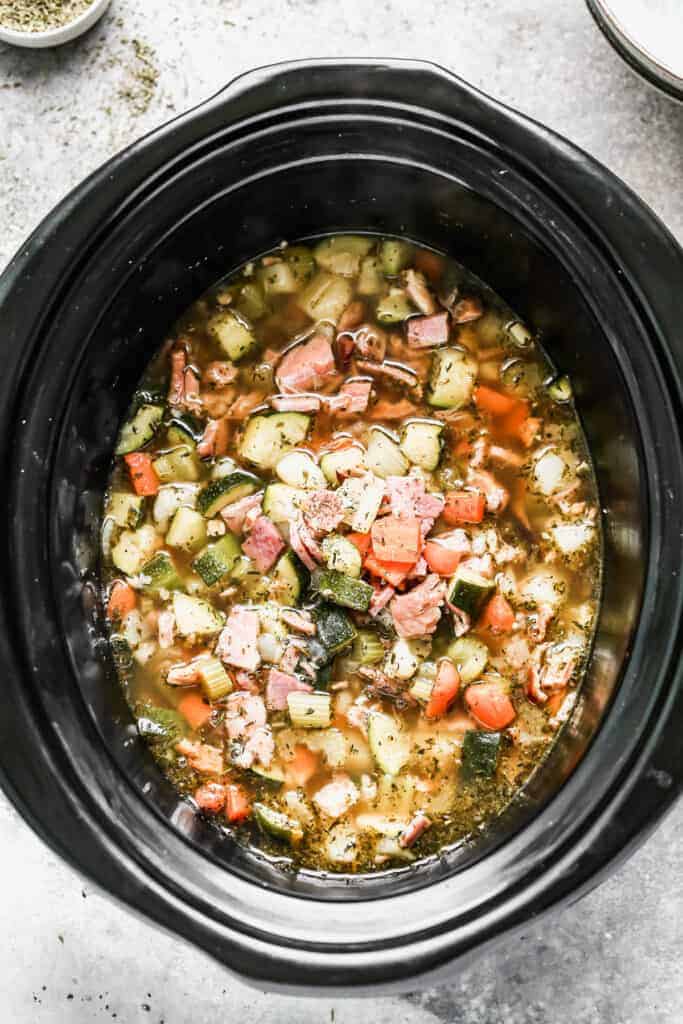 A slow cooker filled with ham bone soup.