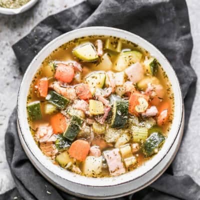 An easy Ham Bone Soup recipe with potatoes, ham, carrots, zucchini, and beans in a delicious broth, served in a bowl.