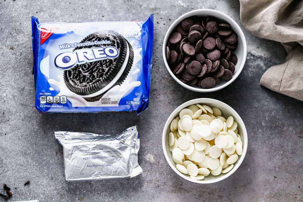 The ingredients needed to make Oreo balls, including a package of Oreos, Cream Cheese and melting wafers.