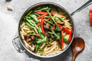 Pasta, vegetables and pasta primavera sauce in a skillet, ready to toss together.