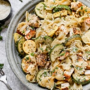 A bowl of healthy Lemon Chicken Pasta recipe filled with chicken, zucchini, squash, parmesan cheese, and herbs.