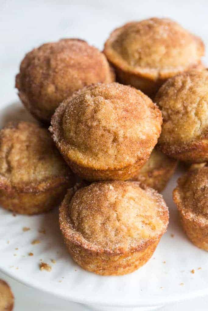 A plate with Snickerdoodle Muffins stacked on it.