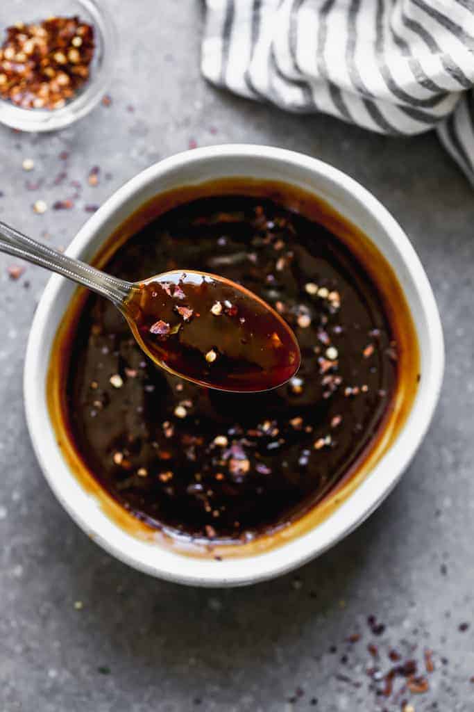 Teriyaki sauce in a bowl with a spoon lifting some out.