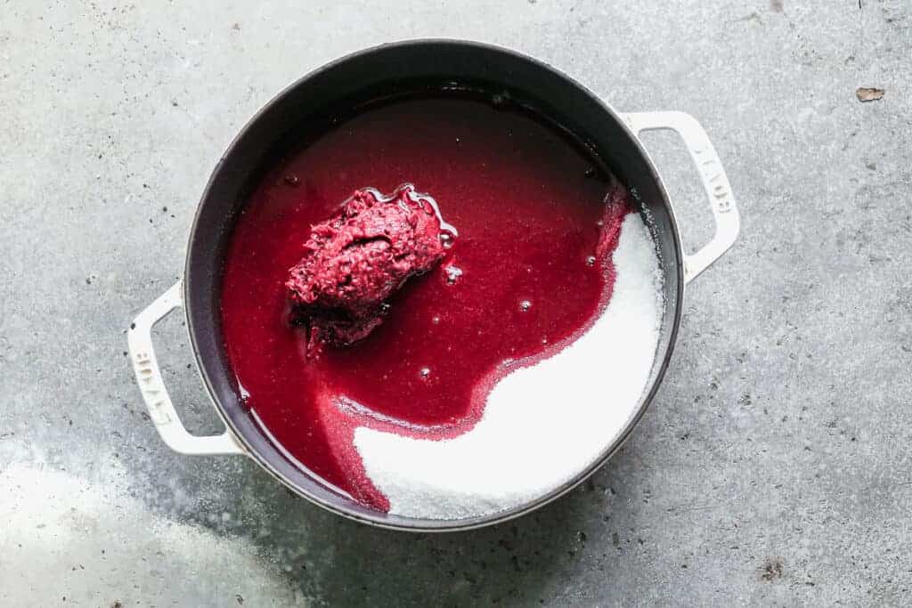 Blackberry juice and sugar in a saucepan.