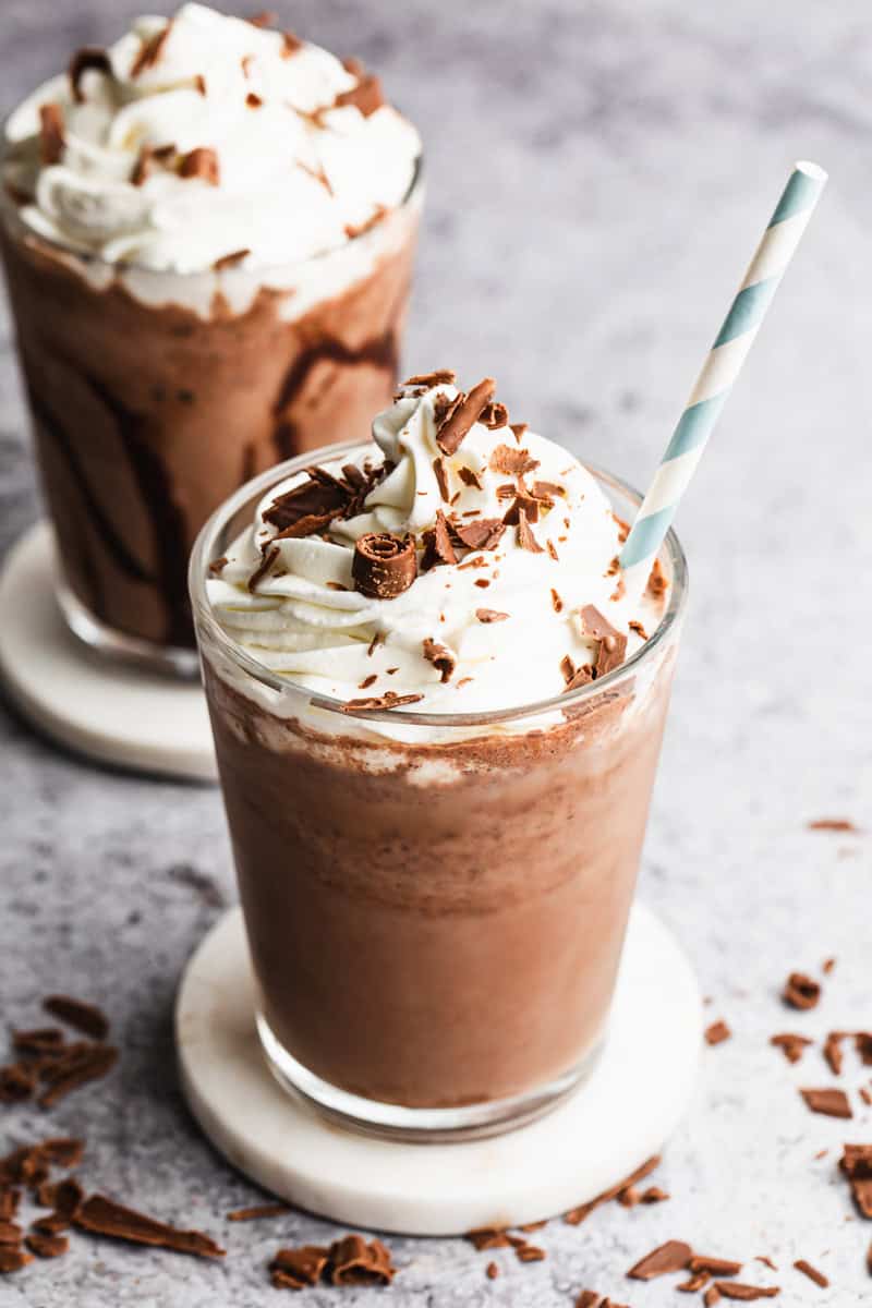 A serendipity Frozen Hot Chocolate recipe in a glass topped with whipped cream and chocolate shavings.