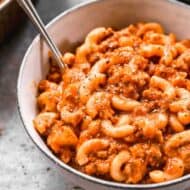 A bowl full of American Goulash made with macaroni noodles, sauce and ground beef.