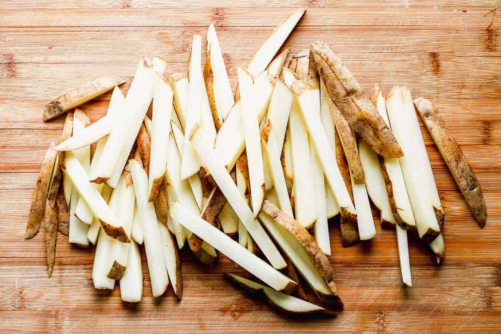 Russet potatoes sliced into thin strips to make fries.
