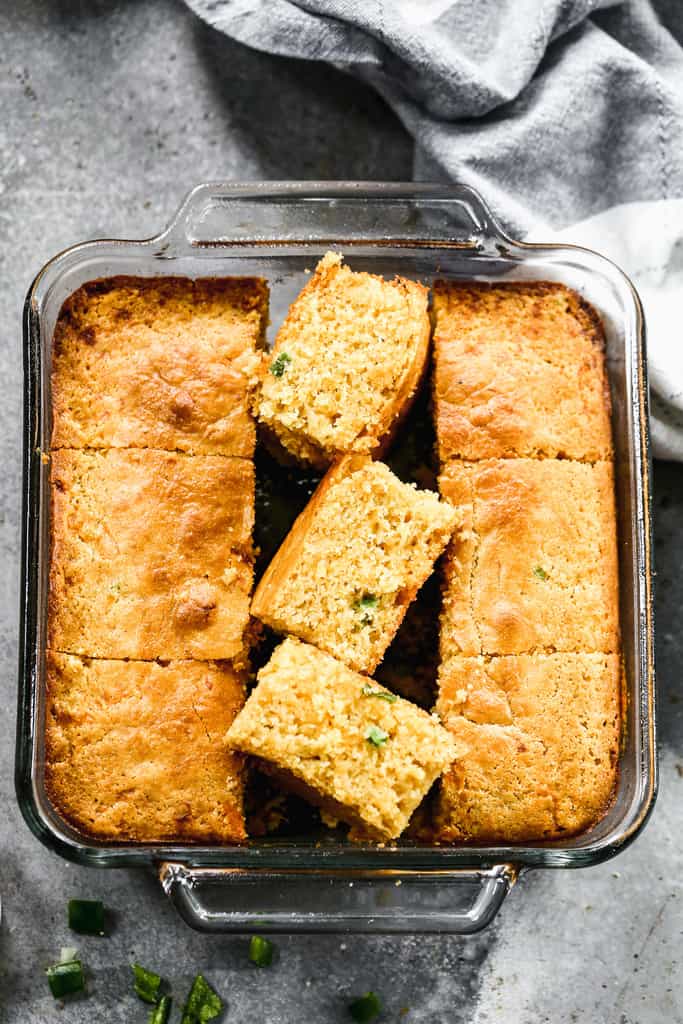 Cheddar Jalapeño Cornbread baked in a square pan and cut into slices.