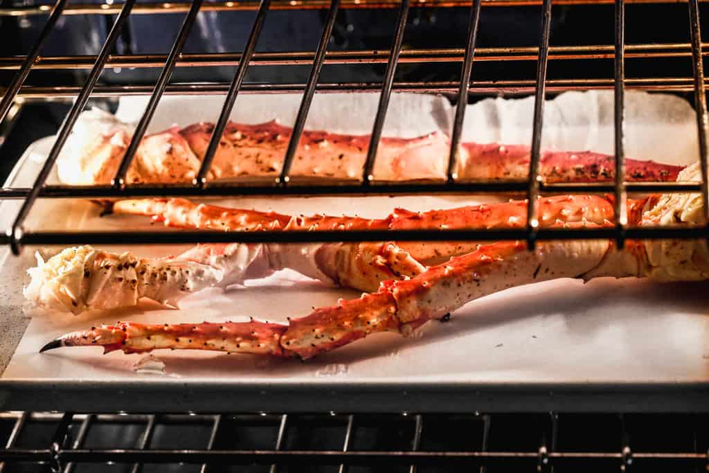 King crab legs baking in the oven on a baking tray.