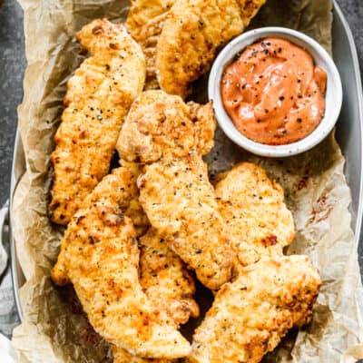 Air Fryer Chicken Tenders served in a basket with dipping sauce.