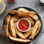 Air Fryer Potato wedges served on a plate, with ketchup for dipping