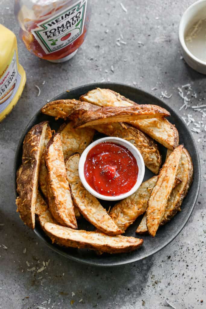 Air Fryer Potato wedges served on a plate, with ketchup for dipping