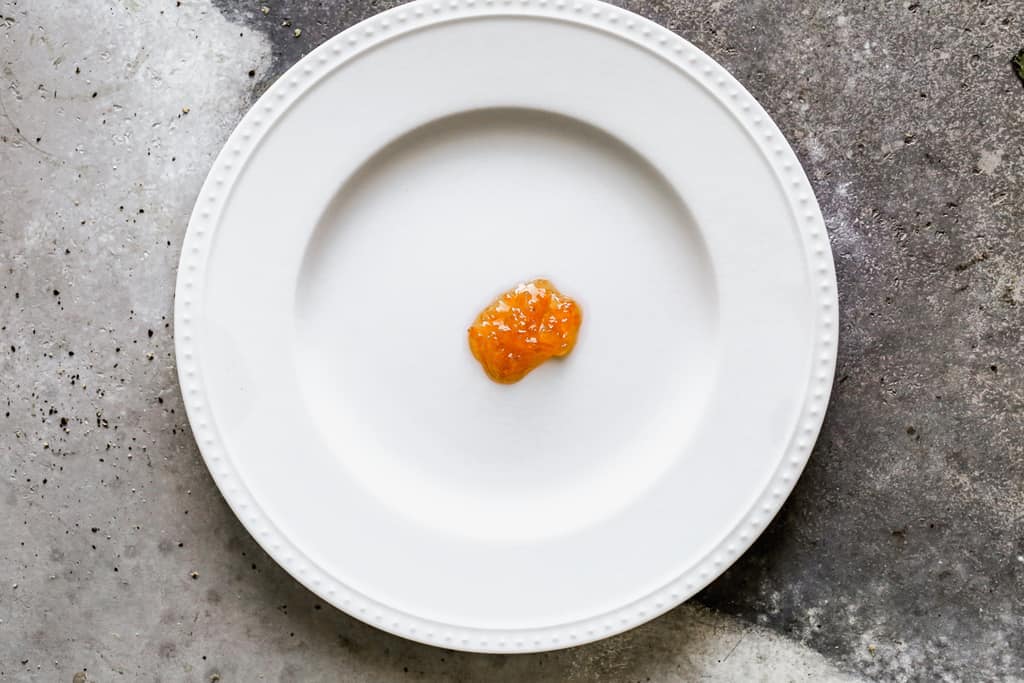 A spoonful of orange marmalade placed on a cold plate, to test of it's ready.