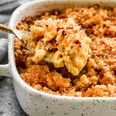The best Baked Mac and Cheese recipe in a square baking dish with a spoonful being lifted up.