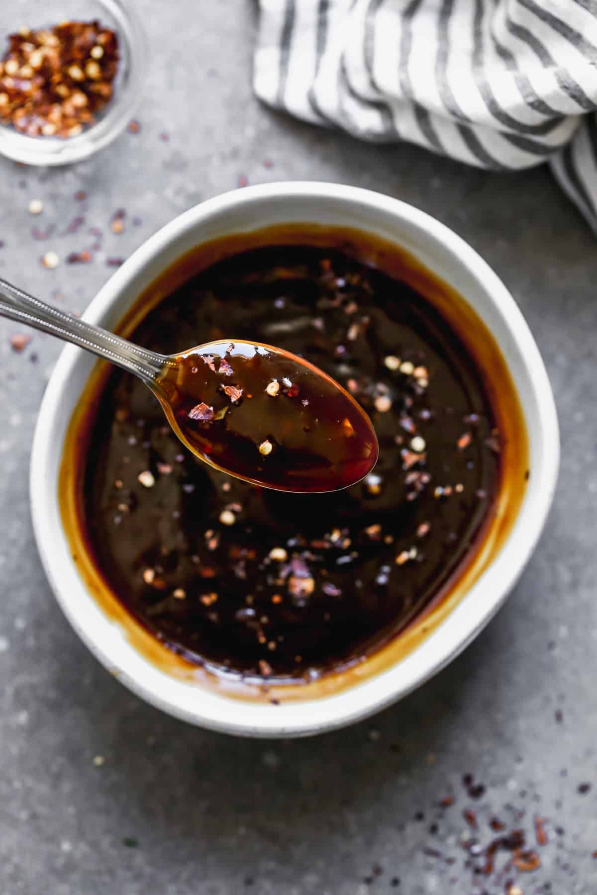 A homemade Teriyaki Sauce recipe in a bowl with a spoon scooping some up. 