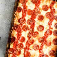 Detroit pizza baked in a steel pan, topped with cheese, sauce and pepperoni.