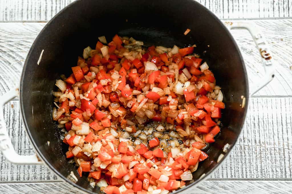 Onion, bell pepper and garlic sautéing in a dutch oven pot.