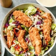 This Applebees Salad recipe has crispy fried chicken on top of lettuce and cabbage and drizzled with the best dressing. It's easy to make and ready in about 30 minutes!
