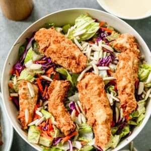 This Applebees Salad recipe has crispy fried chicken on top of lettuce and cabbage and drizzled with the best dressing. It's easy to make and ready in about 30 minutes!