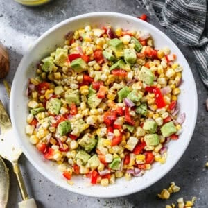 A Summer corn salad with fresh grilled corn, avocado, bell pepper, and onion ready to serve.