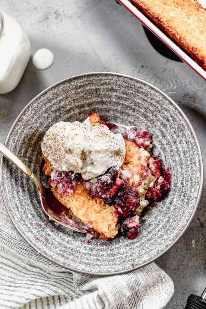 Cherry Cobbler served in a bowl with vanilla ice cream.