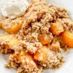 This fresh Peach Crisp recipe has flavorful peaches in a simple sauce then topped with a buttery crumble topping. Serve it with vanilla ice cream to make it truly irresistable.