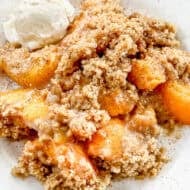 This fresh Peach Crisp recipe has flavorful peaches in a simple sauce then topped with a buttery crumble topping. Serve it with vanilla ice cream to make it truly irresistable.