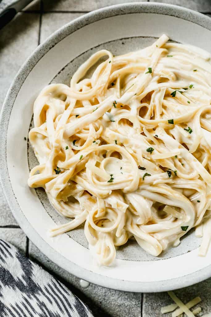A close-up picture of fettuccine alfredo in a bowl, ready to eat.