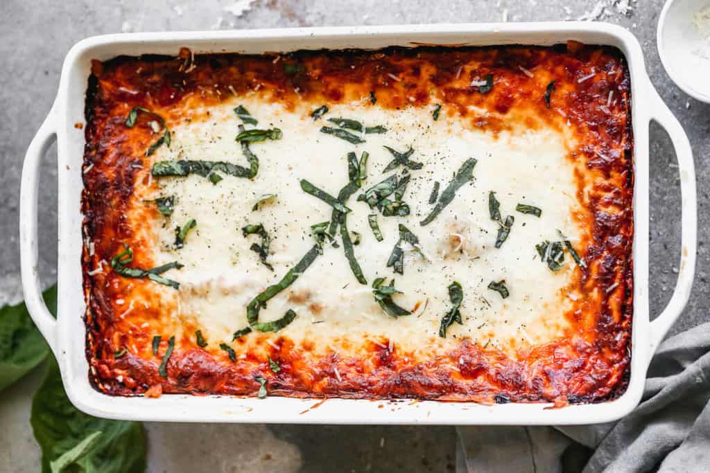 An authentic Homemade Lasagna fresh out of the oven and topped with fresh basil.