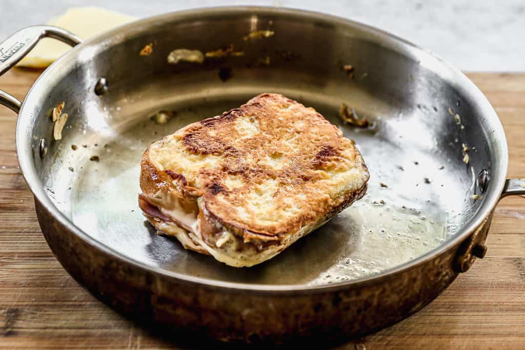 A golden and crispy Monte Cristo sandwich in a frying pan.