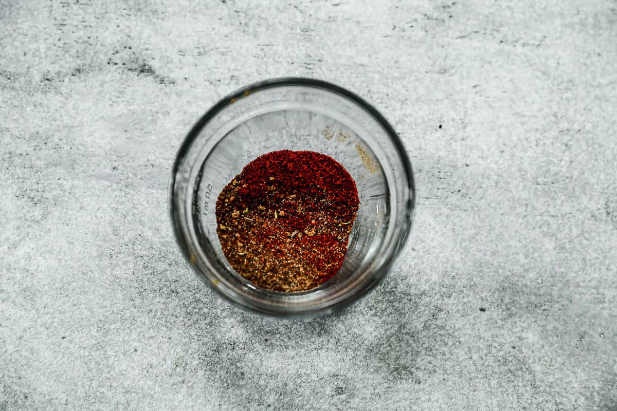 A small glass bowl with seasonings in it to make homemade taco seasoning for ground beef.