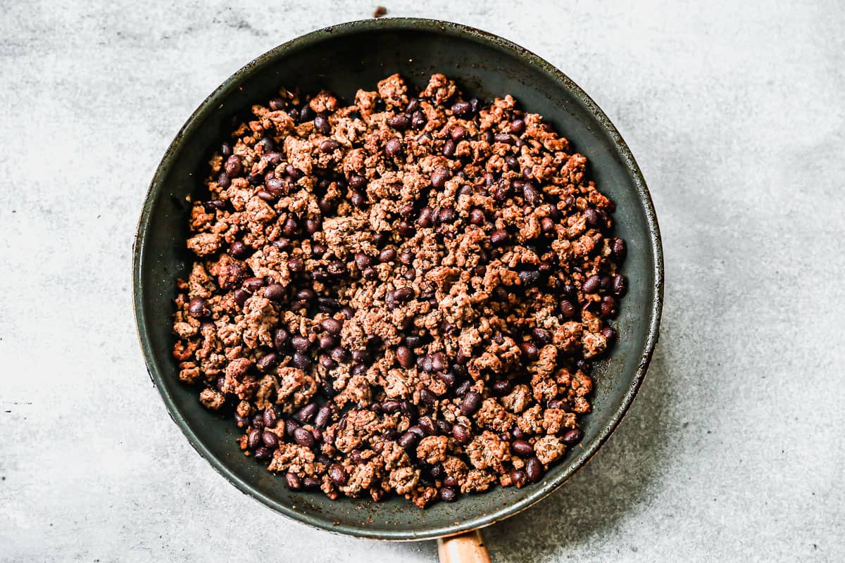 A pan filled with taco meat and black beans, ready for crispy Ground Beef Tacos.