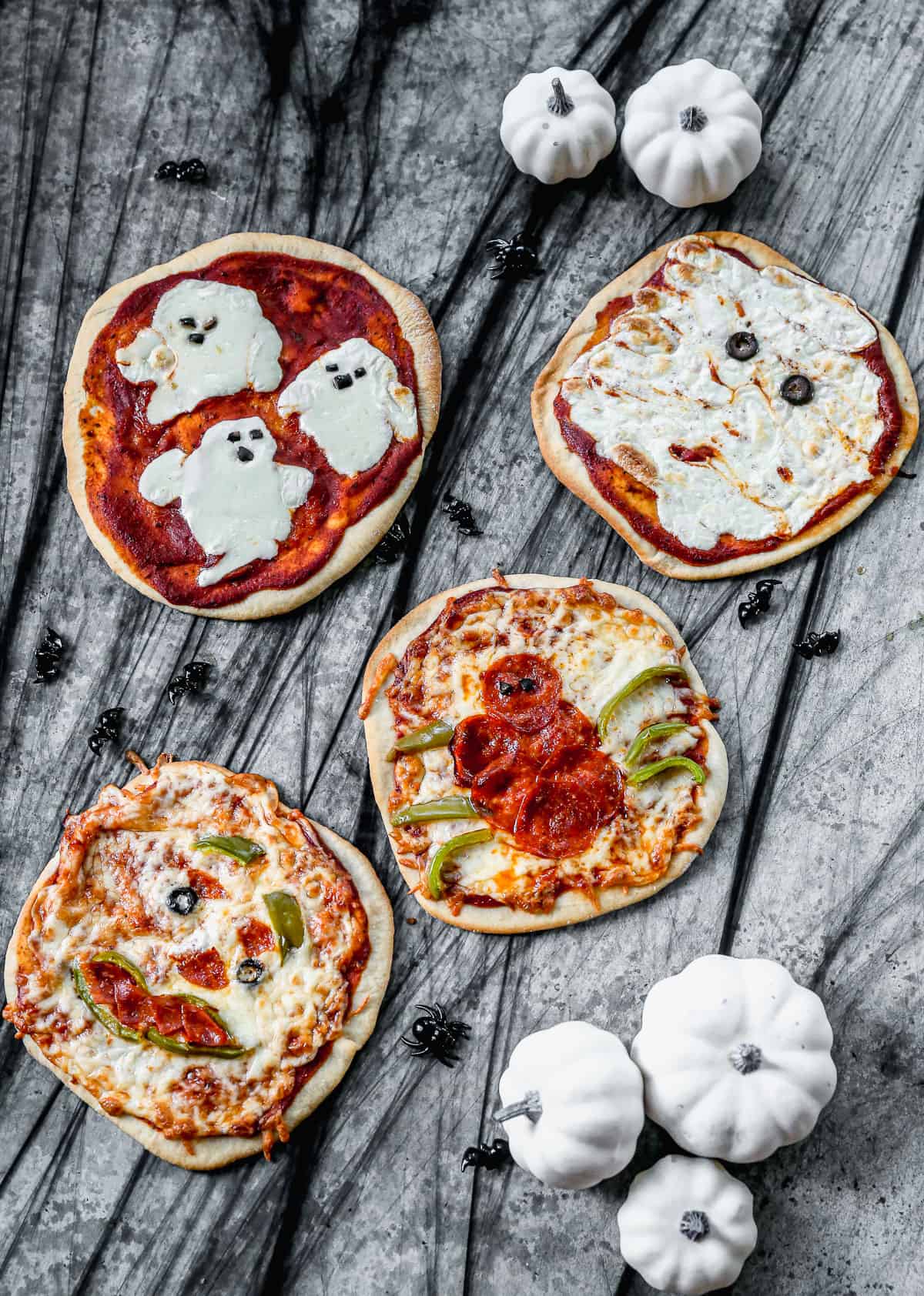 Four themed Halloween Pizzas made with different toppings.