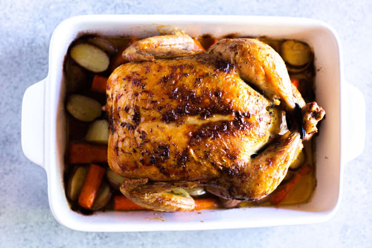 Roast Chicken on top of vegetables, fresh out of the oven.