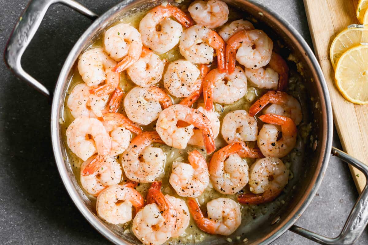 A pan with freshly cooked shrimp in butter for Shrimp Linguine. 