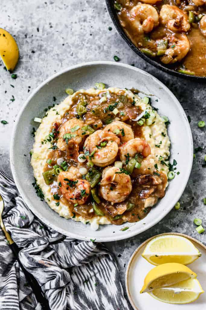 A bowl of Shrimp and Grits topped with green onions and fresh parsley.