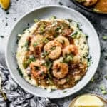 The best Shrimp and Grits recipe served in a bowl topped with flavorful shrimp and a delicious sauce.