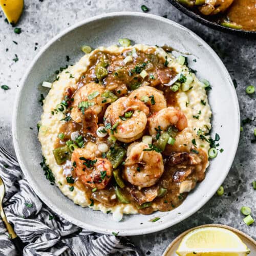 The best Shrimp and Grits recipe served in a bowl topped with flavorful shrimp and a delicious sauce.