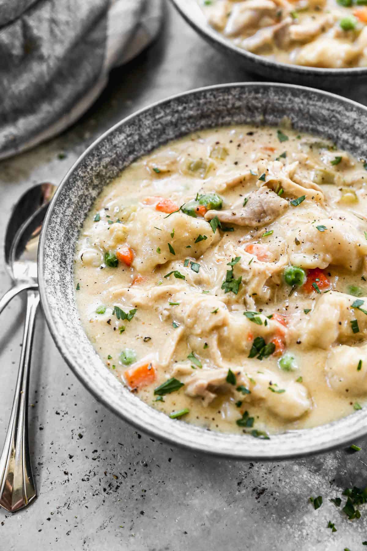 This easy Chicken and Dumplings recipe has a creamy soup with veggies and drop style homemade dumplings that are incredible! This is a family favorite soup that is filling and comforting!