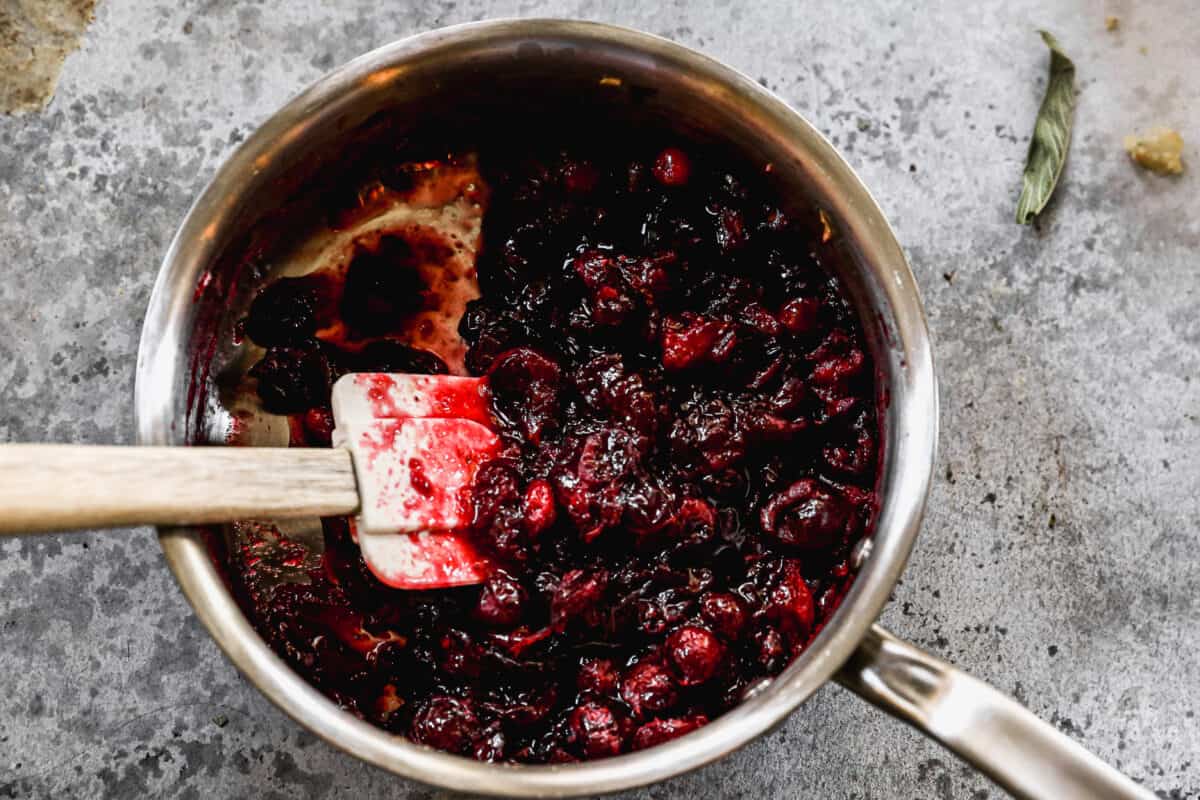 Easy cranberry sauce simmering in a saucepan on the stove. 