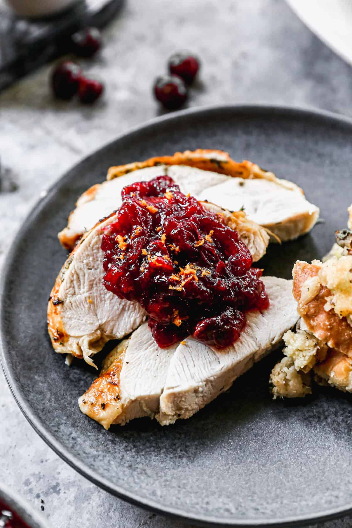 A spoonful of easy cranberry sauce on top of roasted turkey.