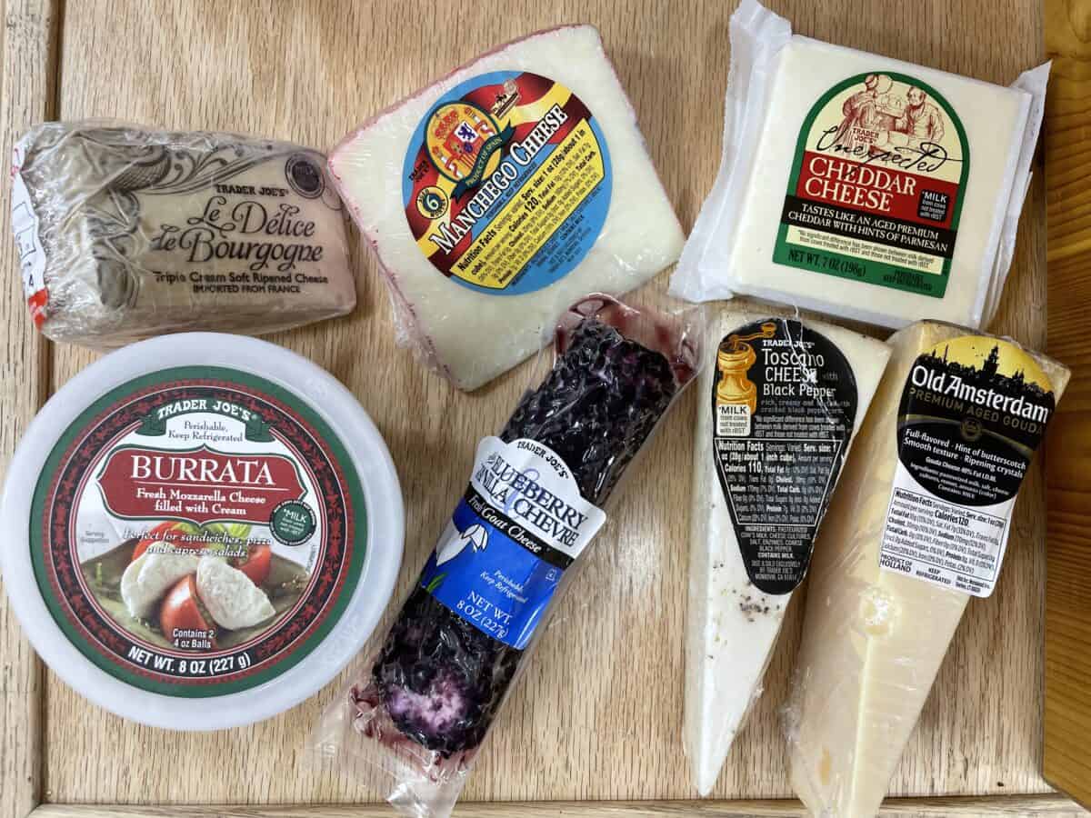 A variety of different cheeses from Trader Joes on a cutting board.