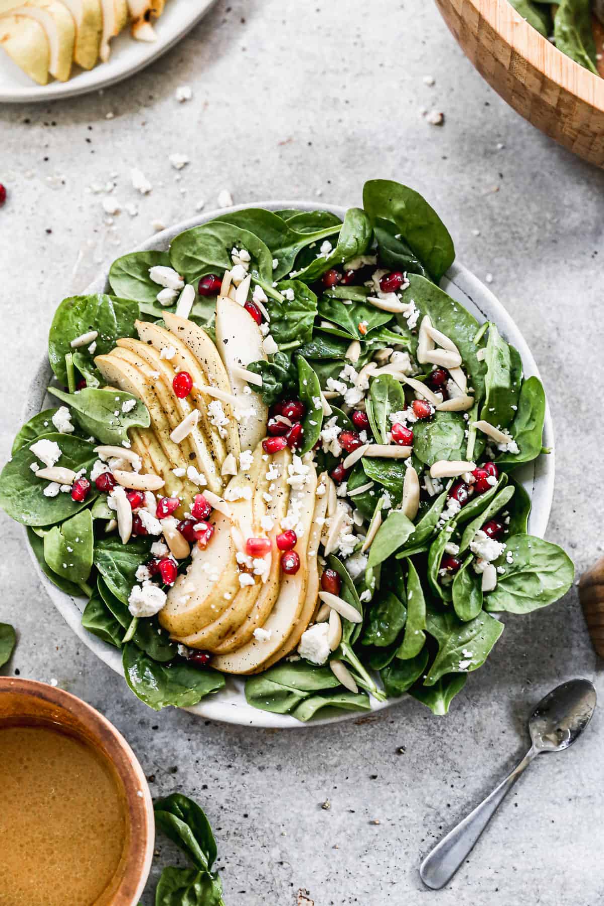 Pear and Pomegranate Salad in a large white serving bowl, ready to serve.
