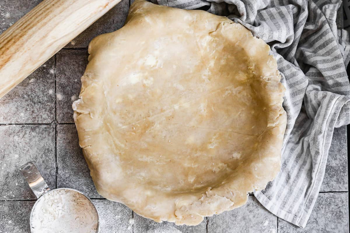 Rolled out pie dough draped in a pie pan. 
