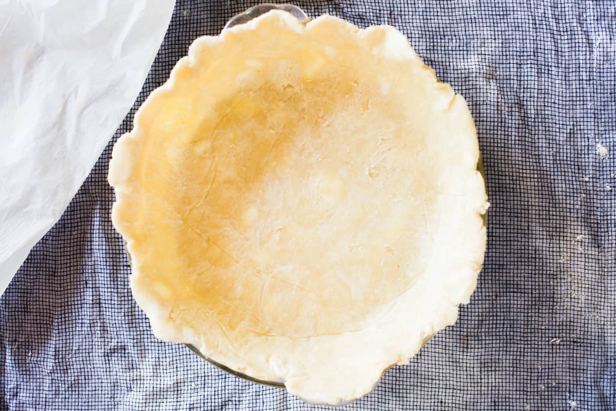 A homemade pie crust in a pie dish.