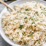 The best Rice Pilaf recipe in a large bowl with chopped parsley stirred in.